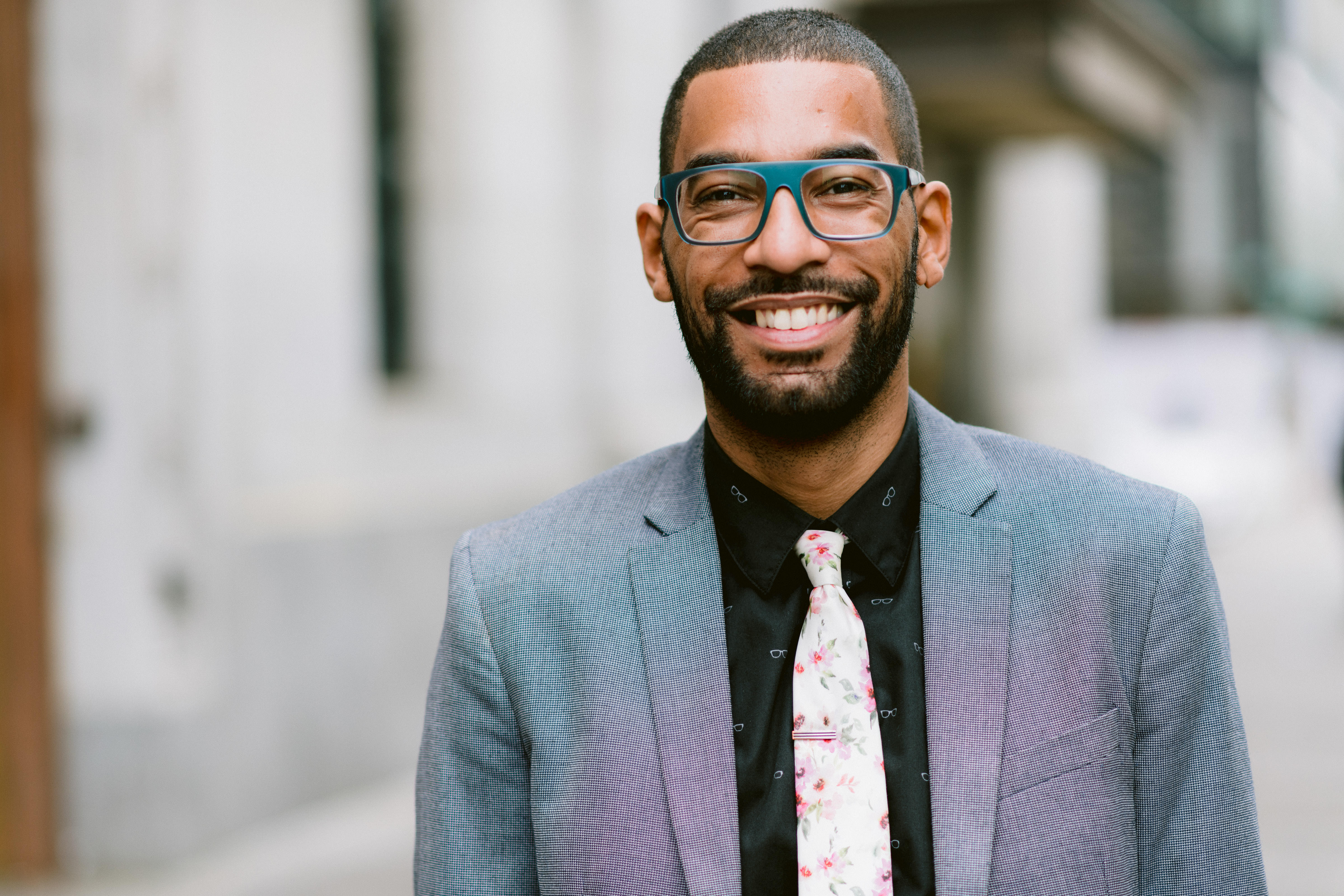 Young African American educator in glasses and cool suit smiles