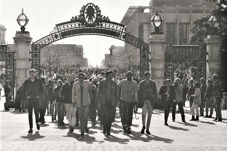 A photo from 1969 of students protesting and walking under Sather Gate
