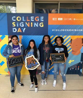 Students posing before the College Signing Day sign
