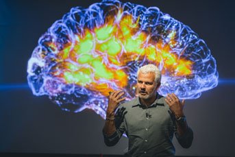 Man in front of a large brain image