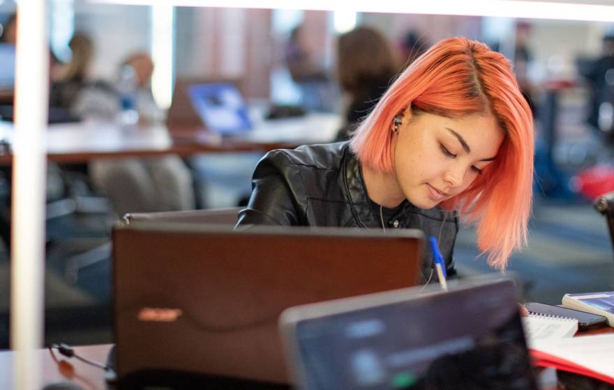 Young woman with orange hair studying