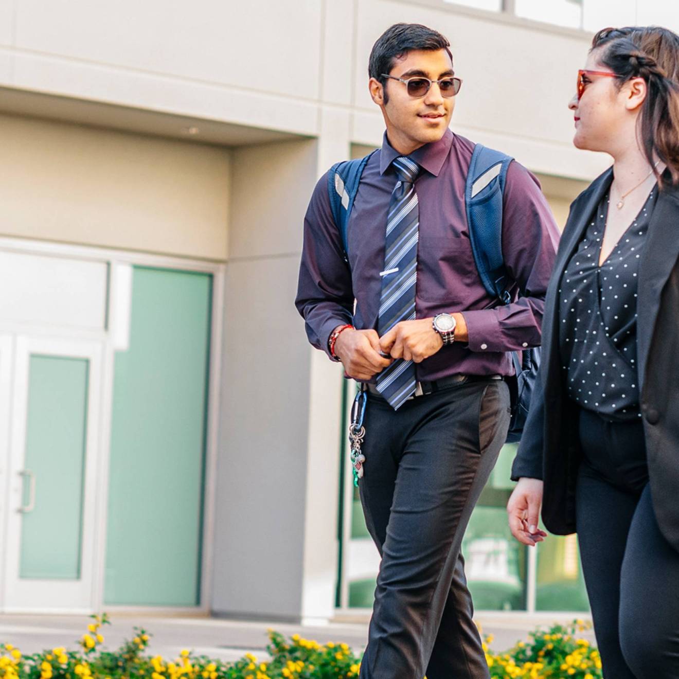 Join the free HireUC career fair August 21 at the Fresno Convention Center Two young people walk outside talking together in business casual clothing