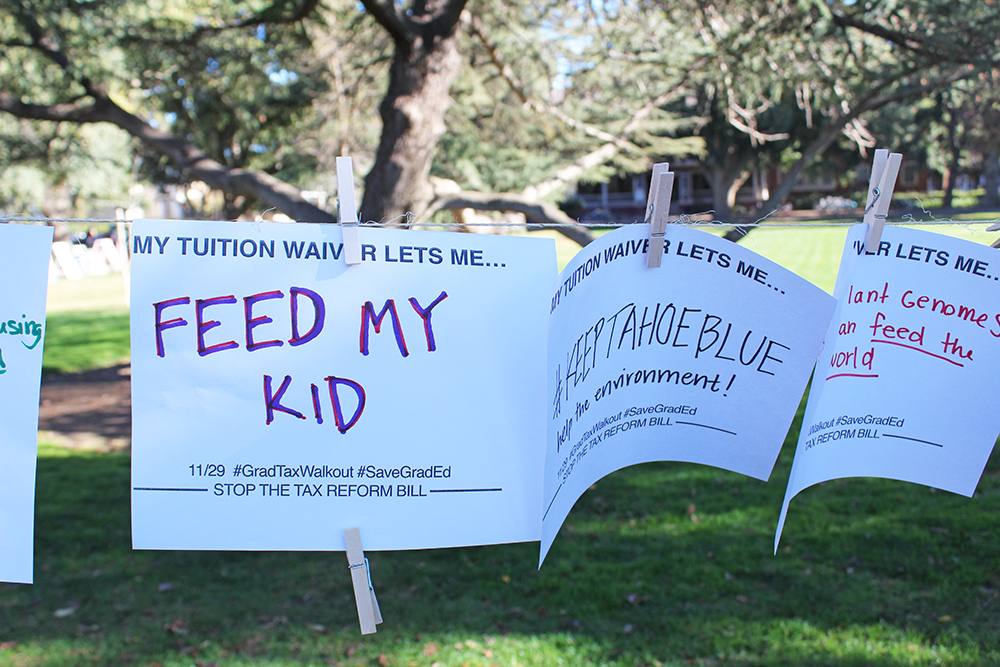Signs displayed saying 'My tuition waiver lets me...' with answers such as 'feed my kid' filled in.