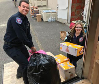 Student firefighter and young girl load trailer