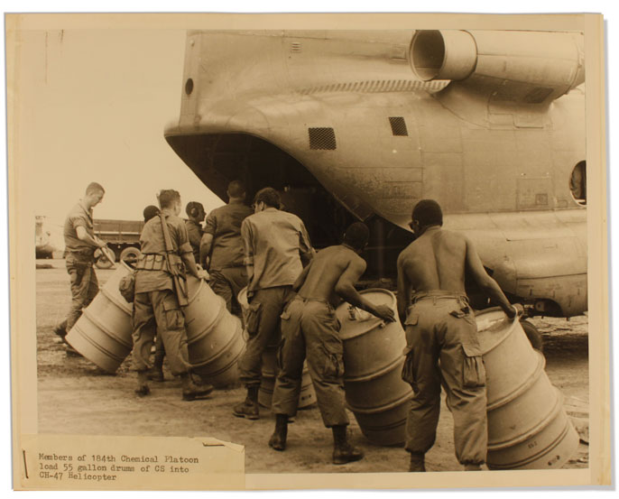 Men load barrels onto a helicopter