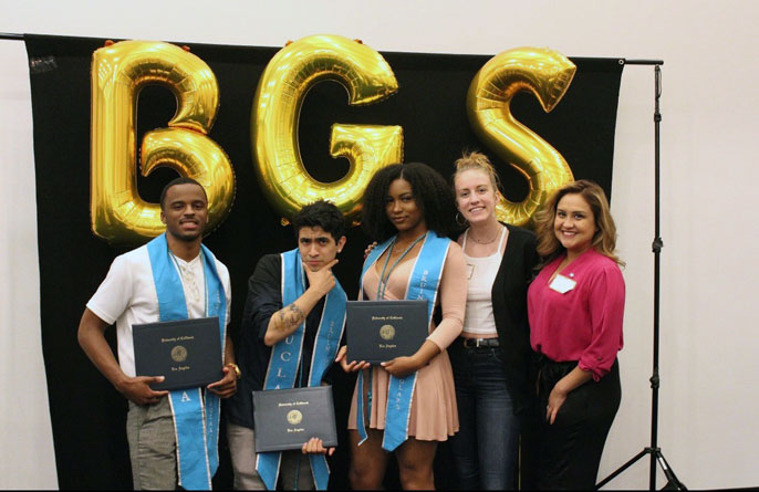 UCLA Guardian Scholars stand for a photo with their diplomas