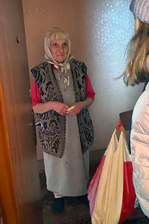 Elderly woman in Ukraine receiving food