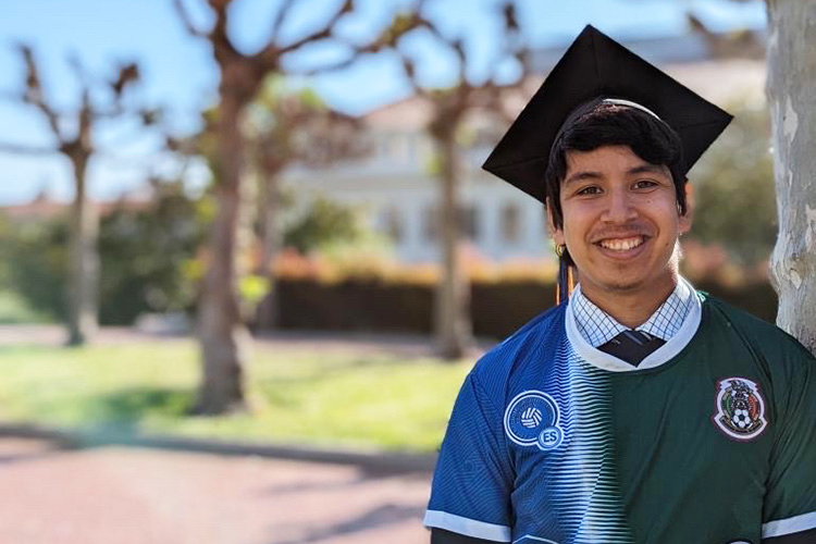 Alberto Ibarra in graduation cap on UC Berkeley campus