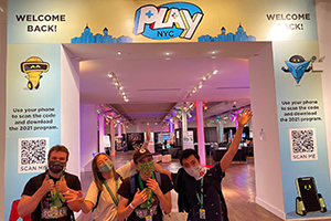Four people posing at a gaming convention hall