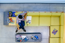 An overhead view of a student studying on a yellow couch