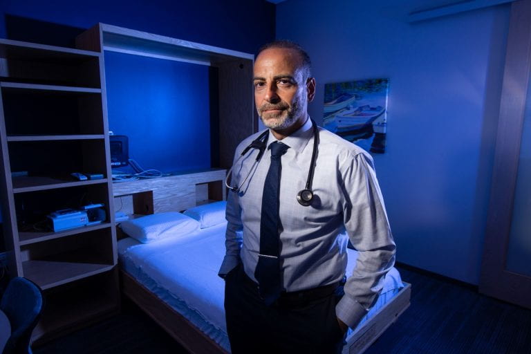 Dr. Rami Khayat in a room with dark blue lighting