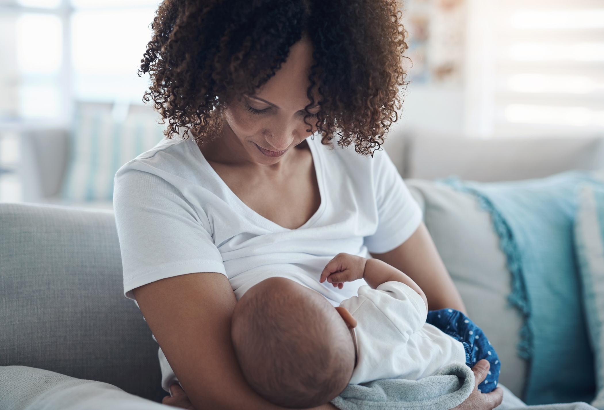 Black woman breastfeeds her infant