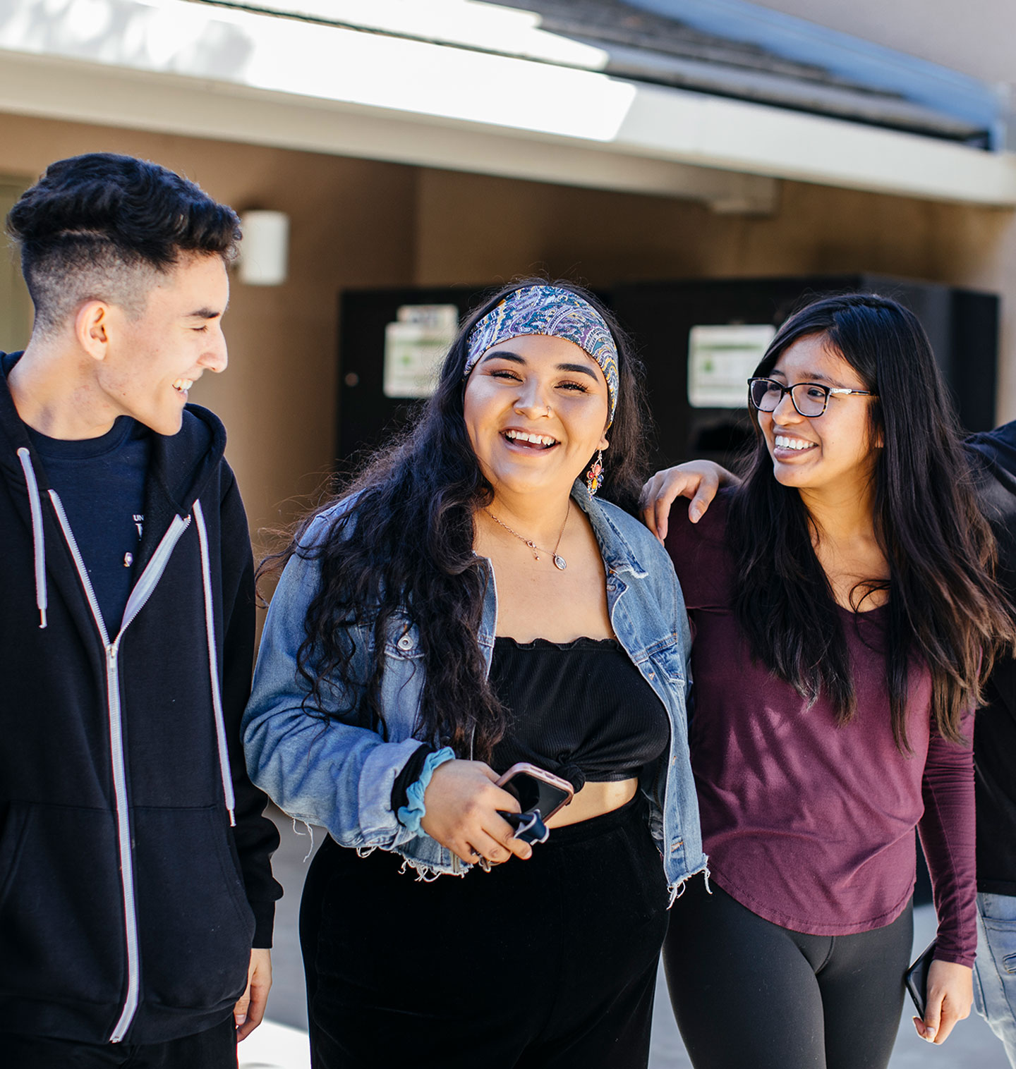 Three students of color laughing and chatting