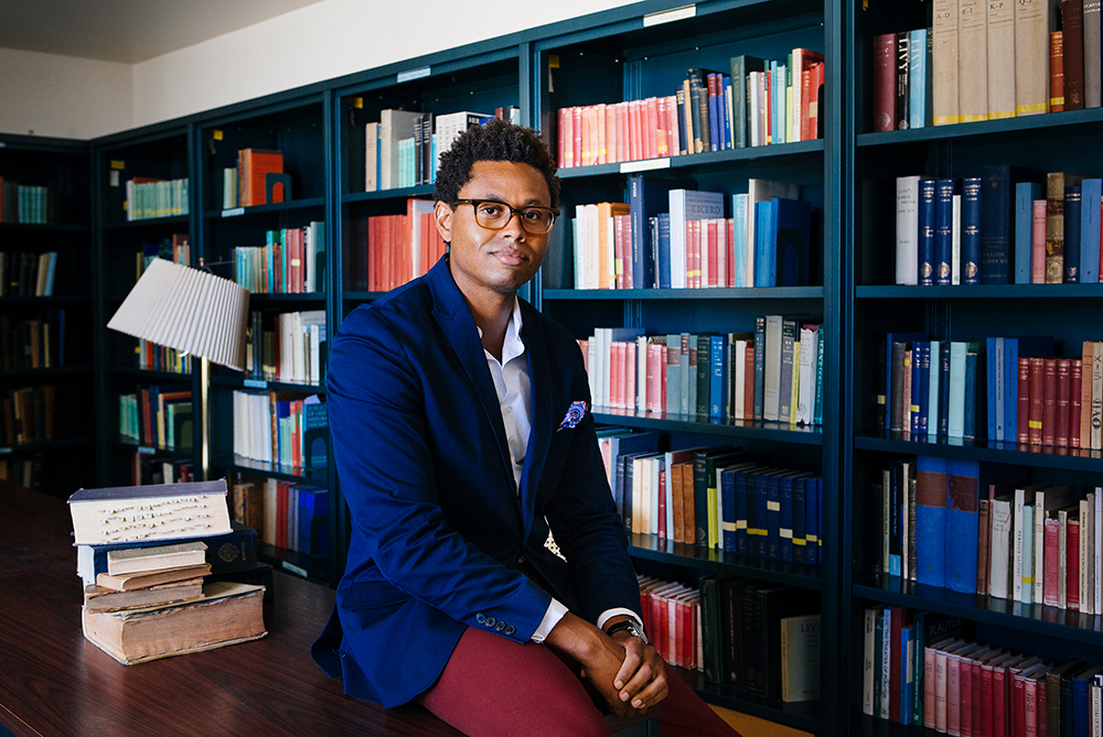 Young Black scholar with glasses in library