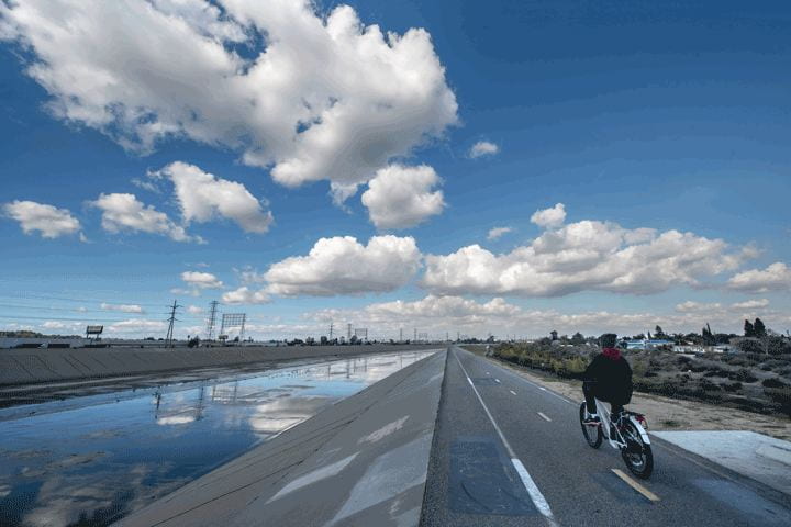 A cyclist riding on a path along the LA River
