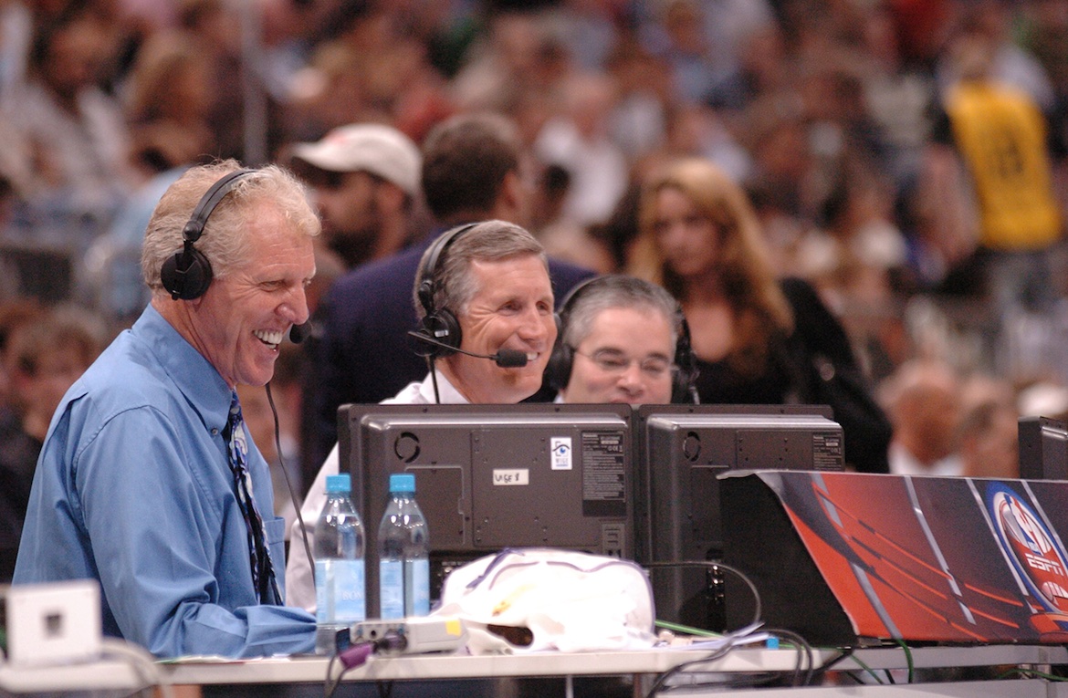 Bill Walton wearing headphones, calling a game on the sidelines