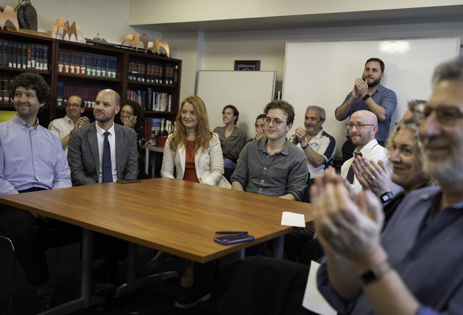 People sit around a table at ProPublica, celebrating winning a Pulitzer