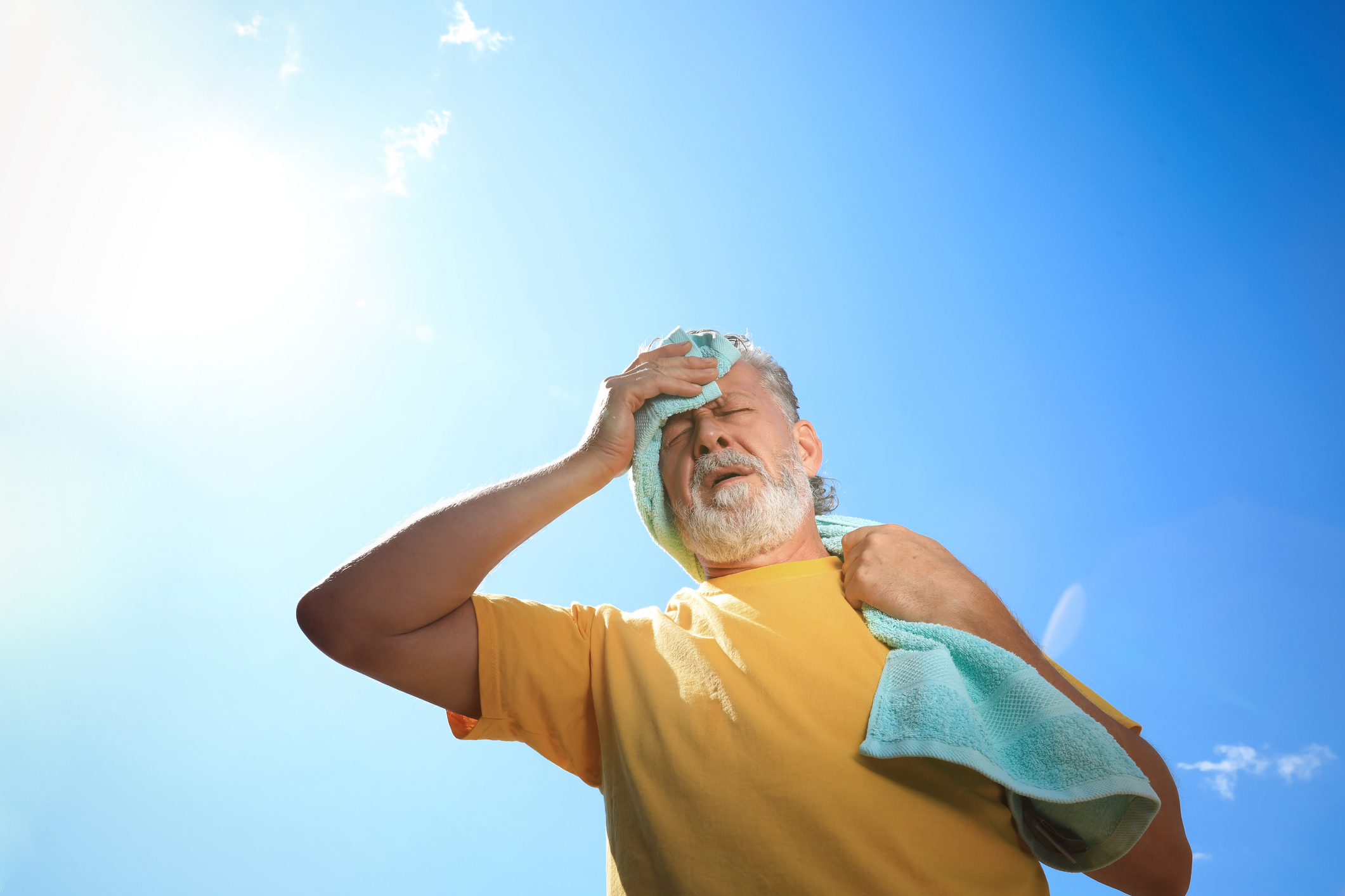 Man wipes brow on a hot day