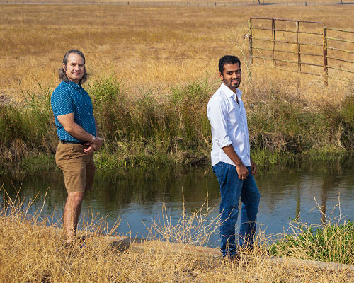 Shawn Newsam and Shrishail Baligar stand on the banks of a slough 