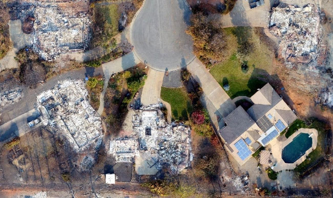 Aerial image of a cul de sac, where 4 homes have burned down and one stands unscathed