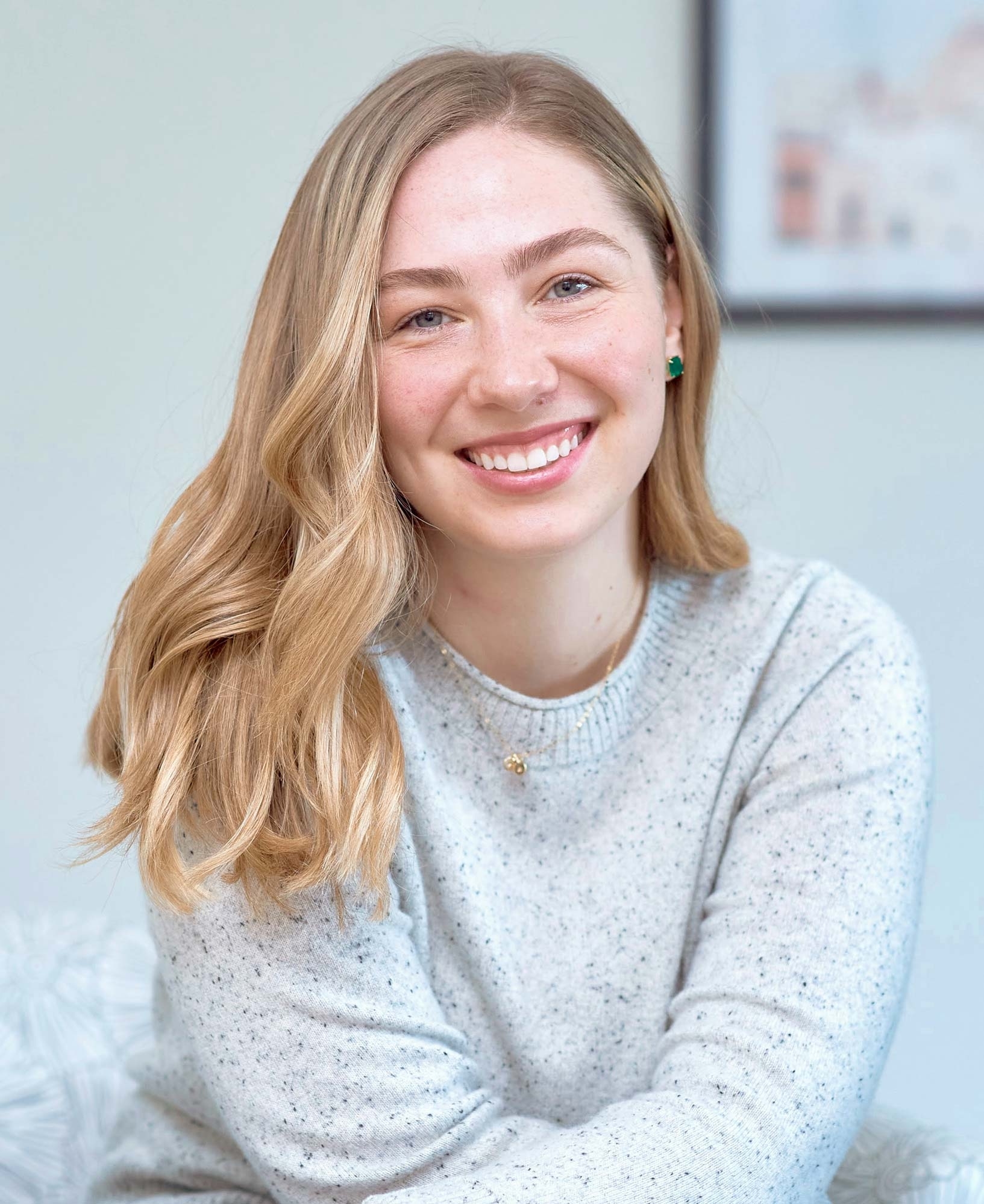 Laura Pritschet smiles, leaning slightly forward, wearing an oatmeal-colored sweater