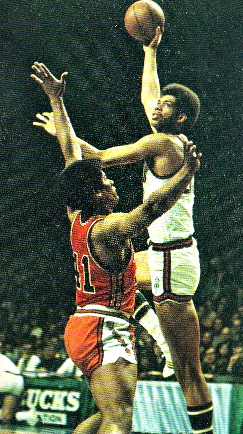 Kareem Abdul-Jabbar raises his right arm to shoot the basketball over a defender in a NBA game in the 1970s