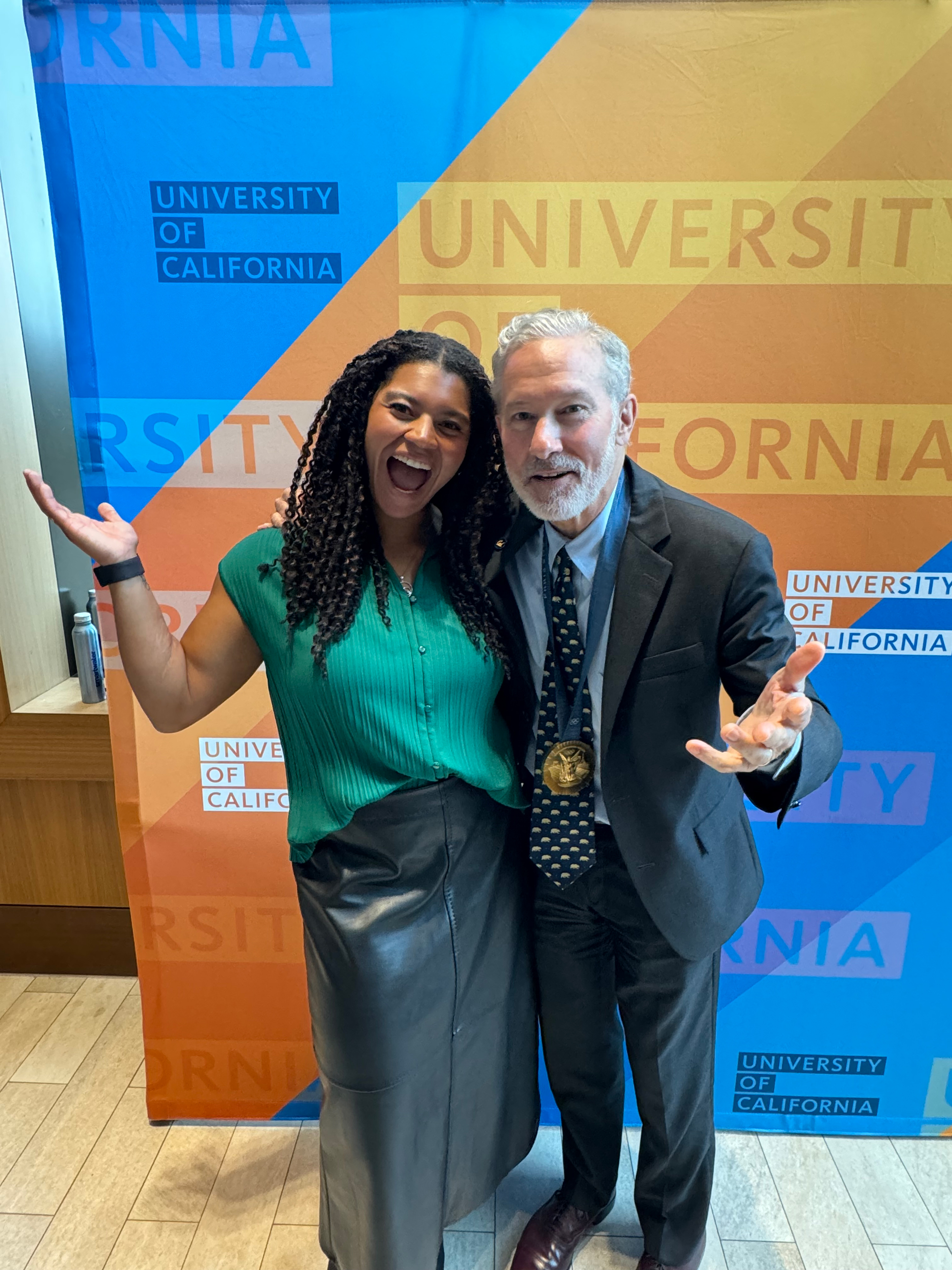 Camryn Rogers, smiling and laughing, poses next to UC Berkeley chancellor Rich Lyons