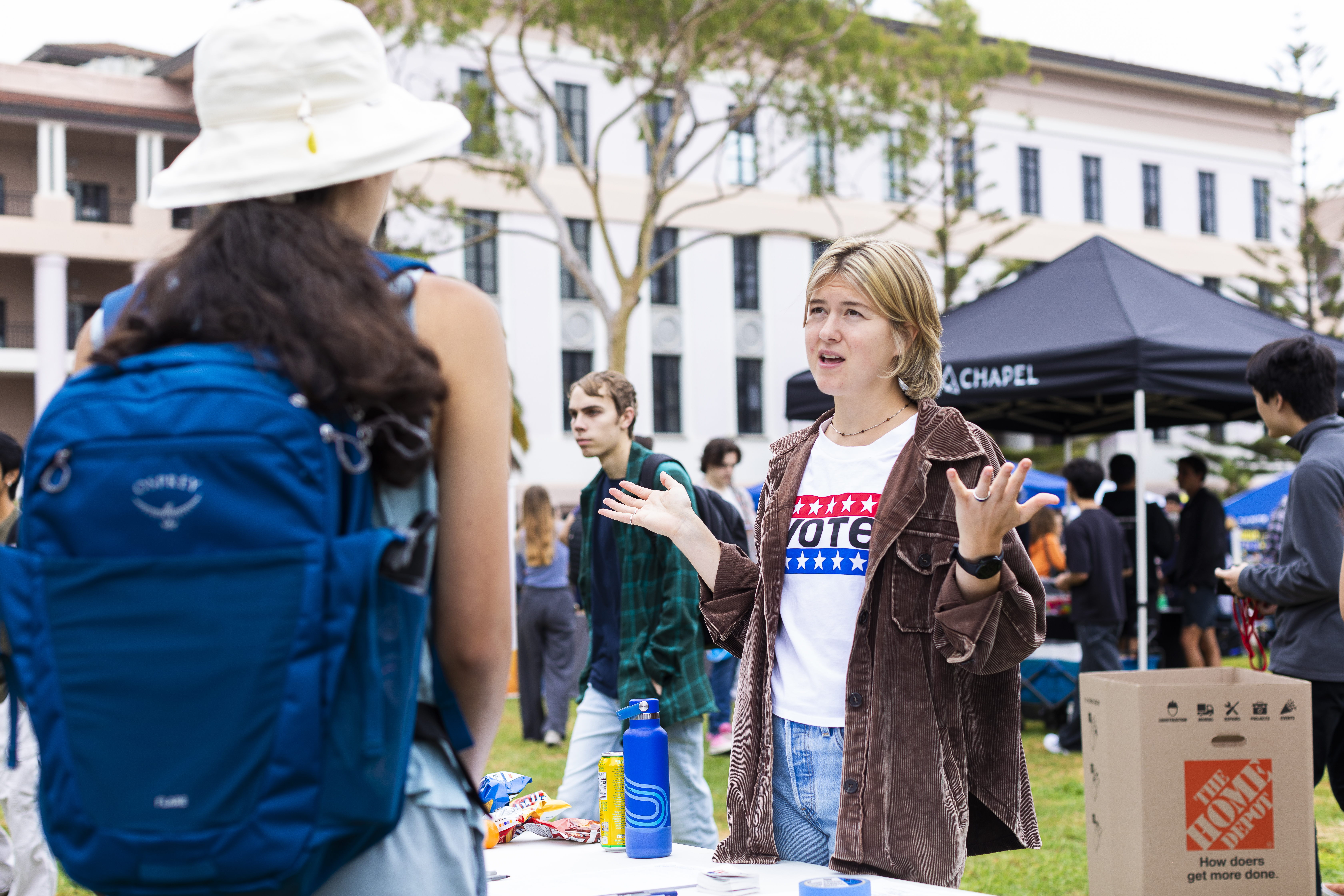 Jeanne Broome speaks with a fellow student at an info booth on UCSB campus.