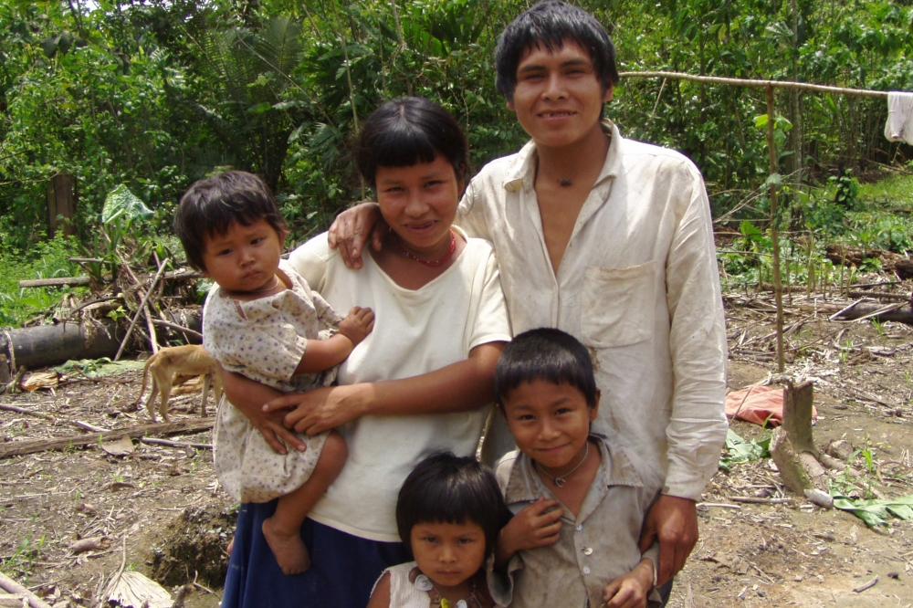 A Tsimane family in the Amazon smiles for a portrait: mom, dad, and 3 kids