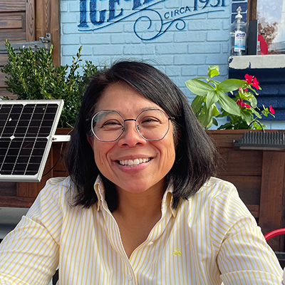 A woman with a dark bob and glasses smiles