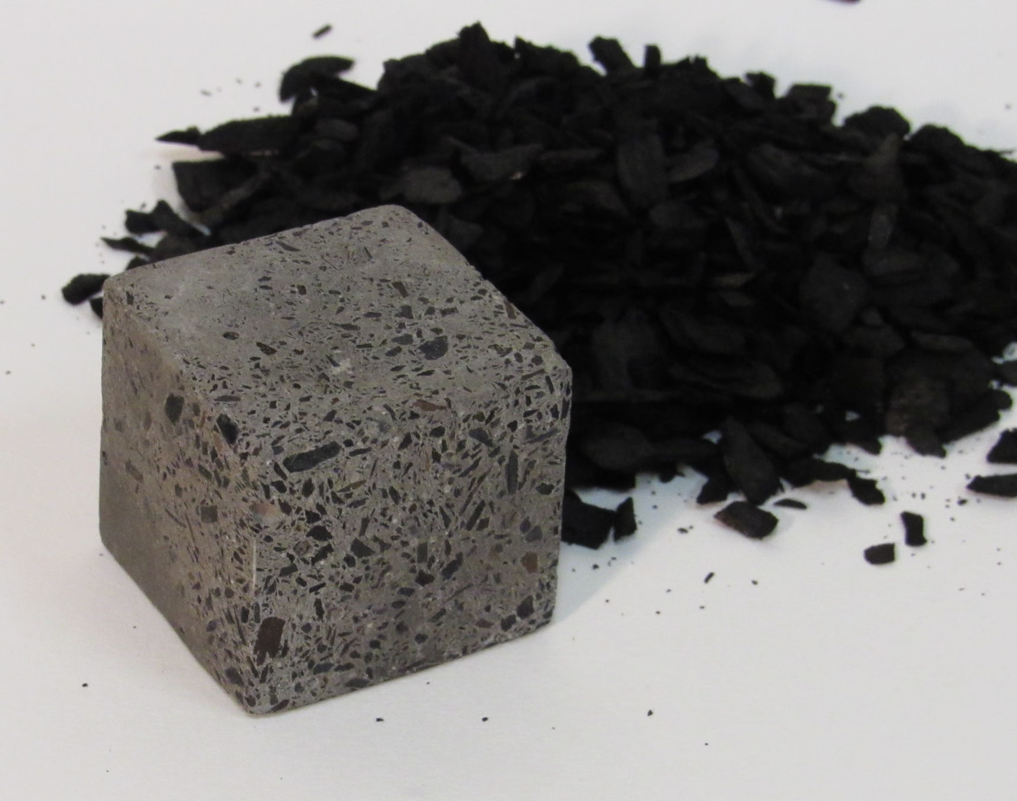 A dense block that looks like pumice next to thick black scattered ash-like substance