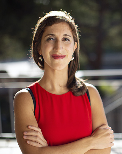 Woman in red dress with long hair crosses arms