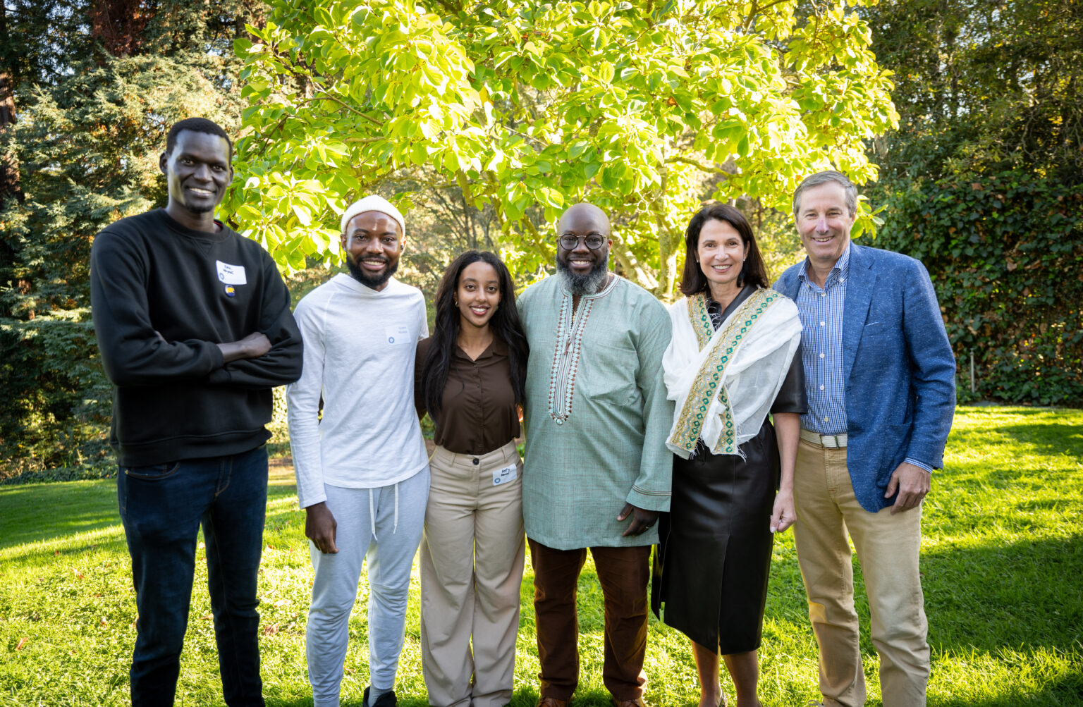 Several students with UC Regent Mark Robinson and Stephanie Robinson on a bright, grassy area of the UC Berkeley campus