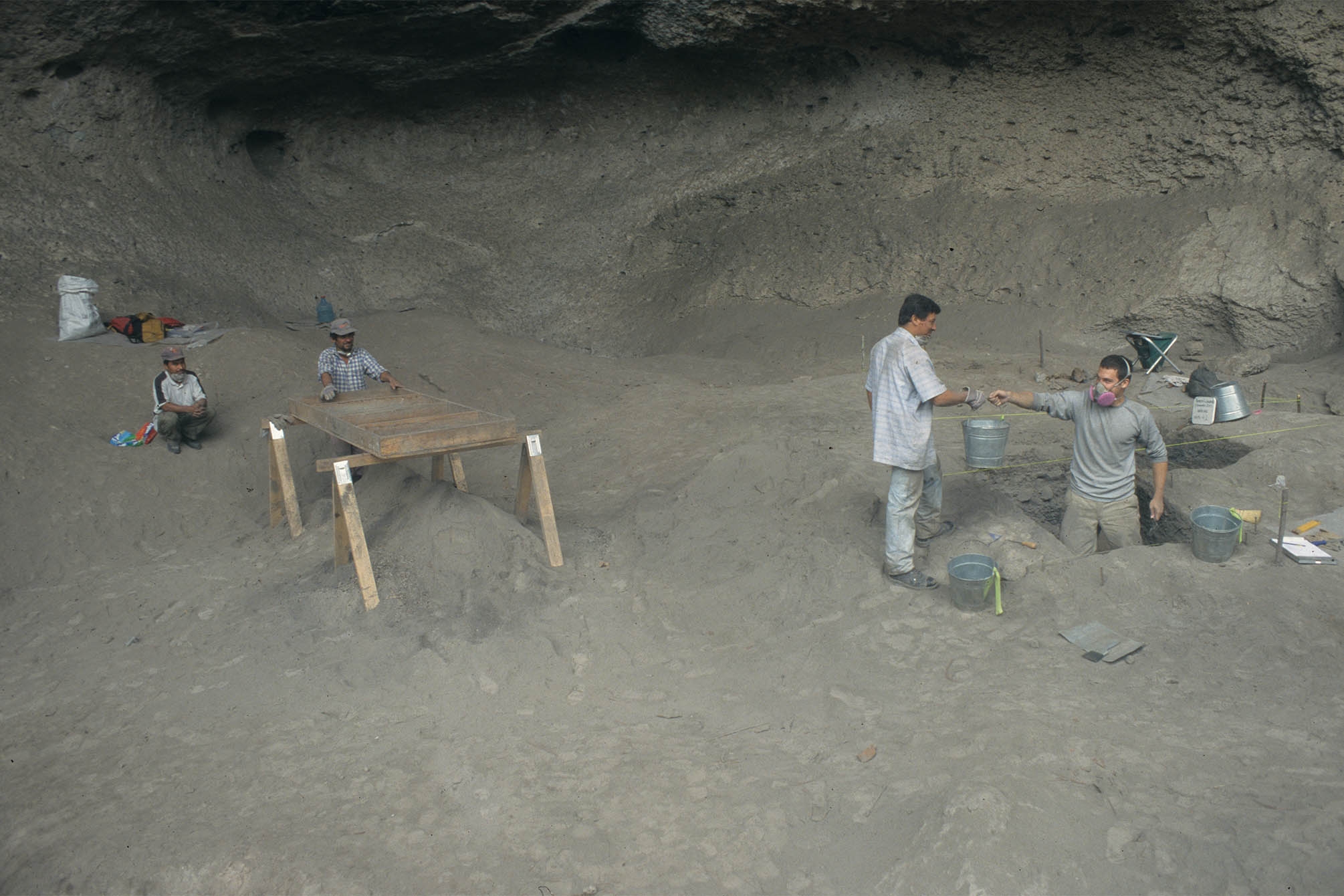 Archaeologists excavating inside a cave