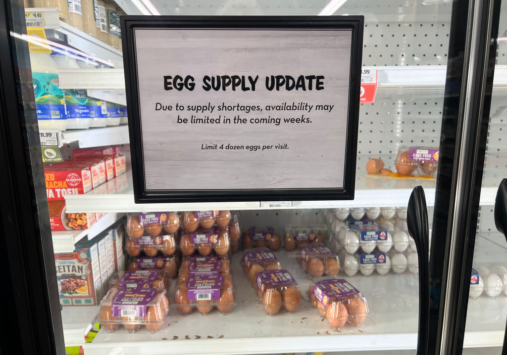 A sign on a nearly-empty egg case at a grocery store reads: "EGG SUPPLY UPDATE: due to supply shortages, availability may be limited in the coming weeks. Limit 4 dozen per customer." 