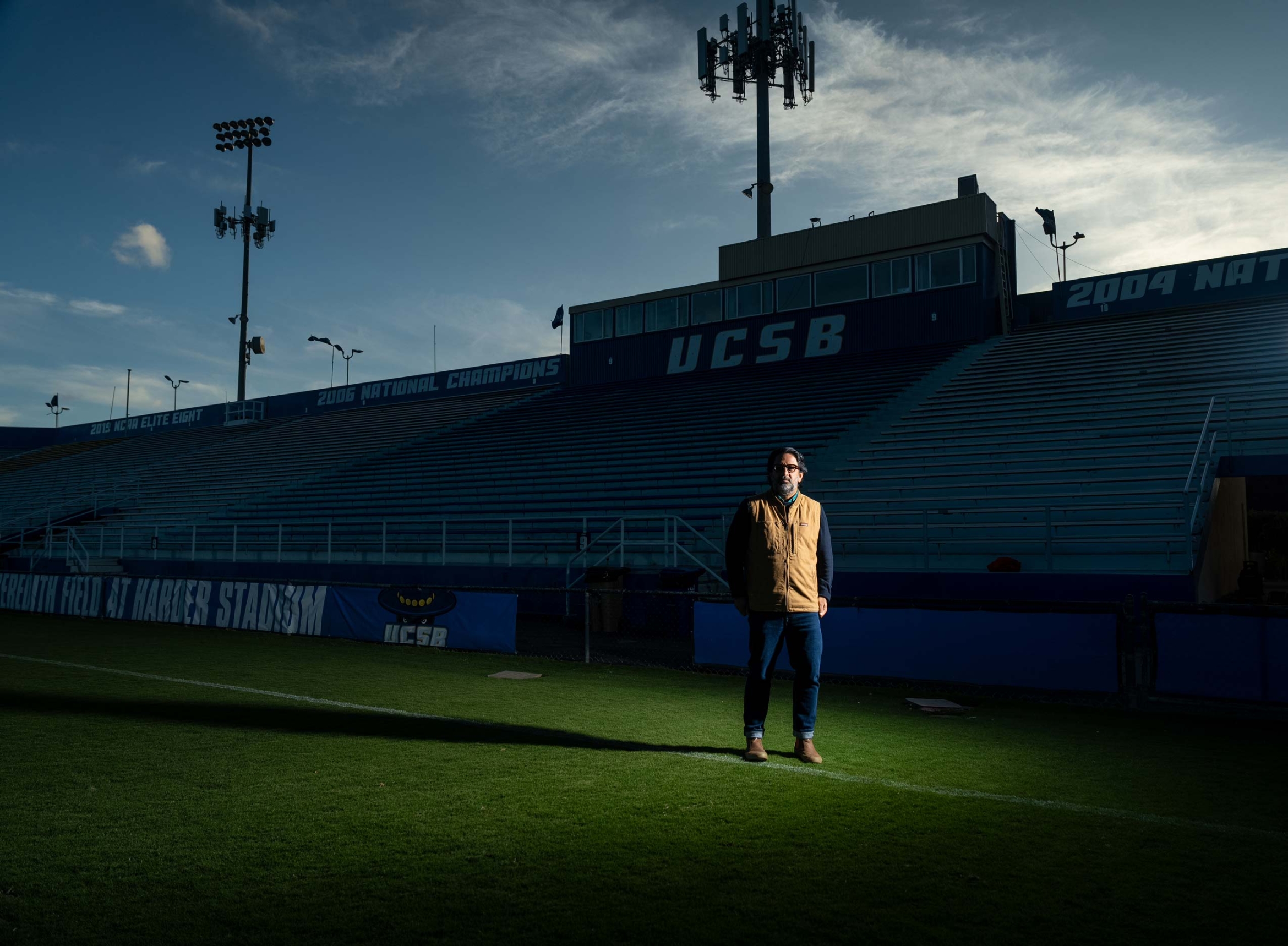 A man stands in a heavily shaded empty sports complex