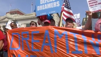 People marching in support of DACA hold a banner. Still from Washington Post/Reuters video