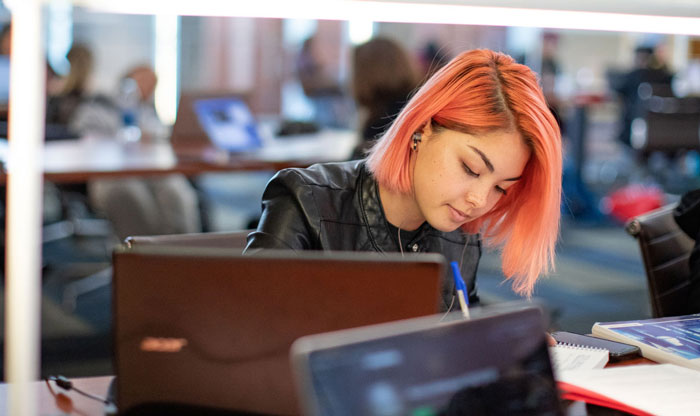 Young woman with orange hair studying