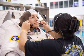 Meir in astronaut gear getting headset put on