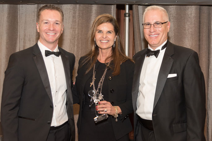 Maria Shriver at a gala with two men