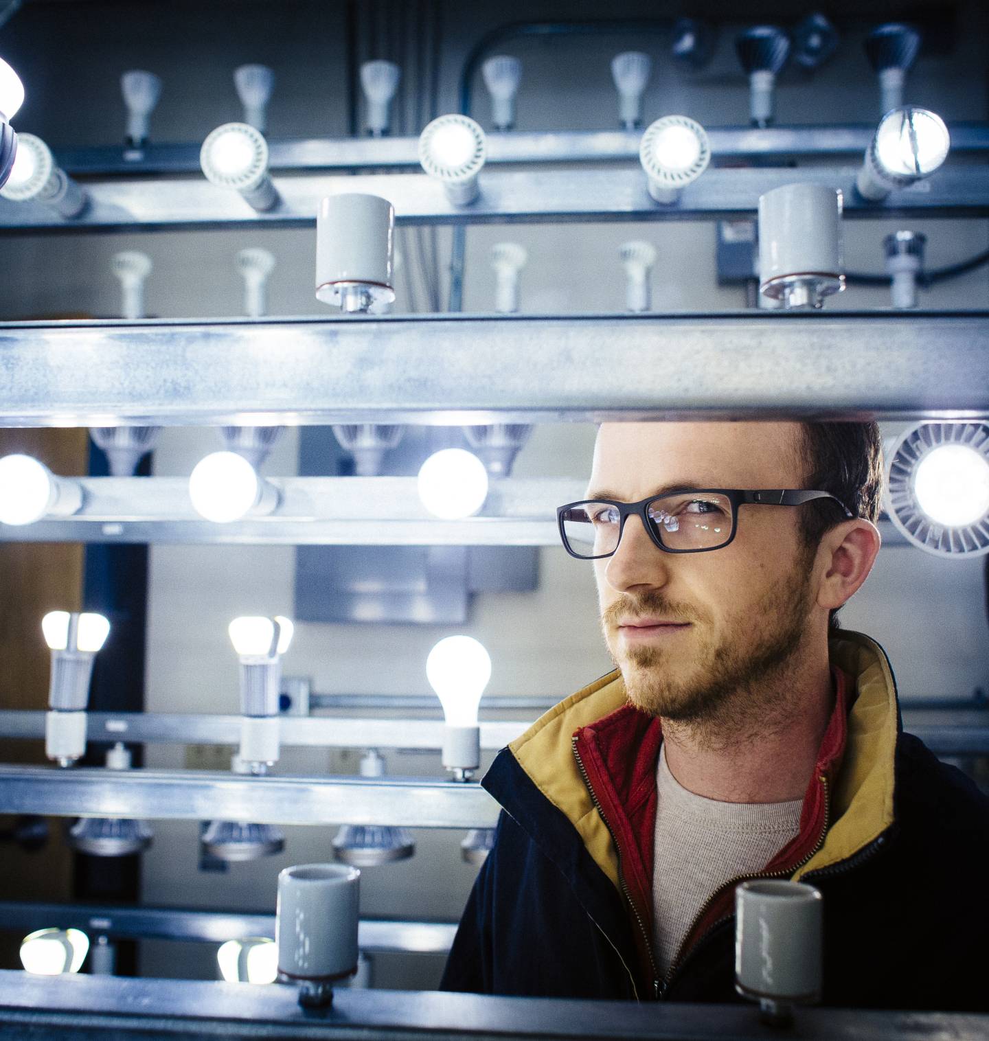 a researcher looks out through a bank of lightbulbs
