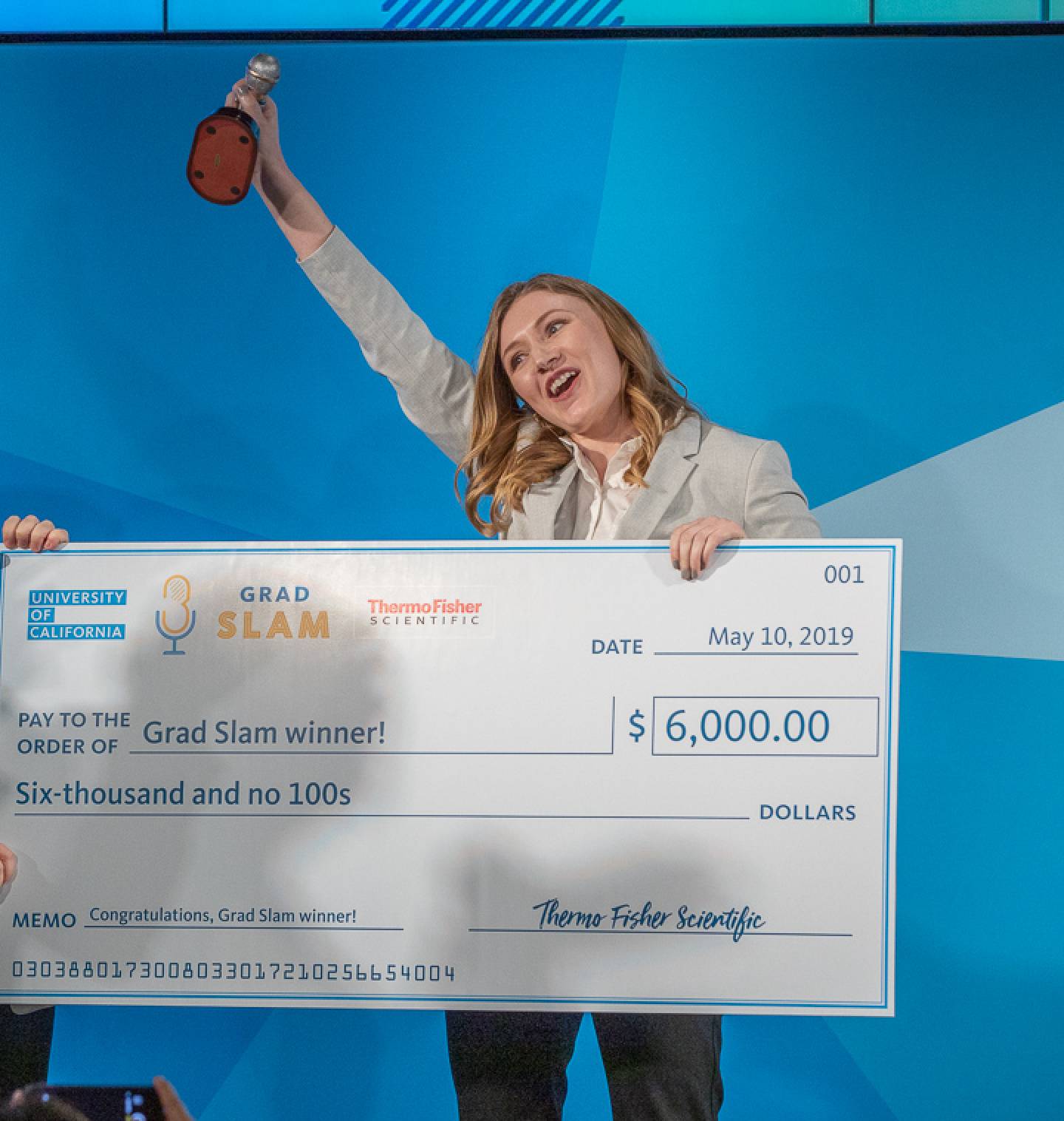 Student holding a giant check for $6,000