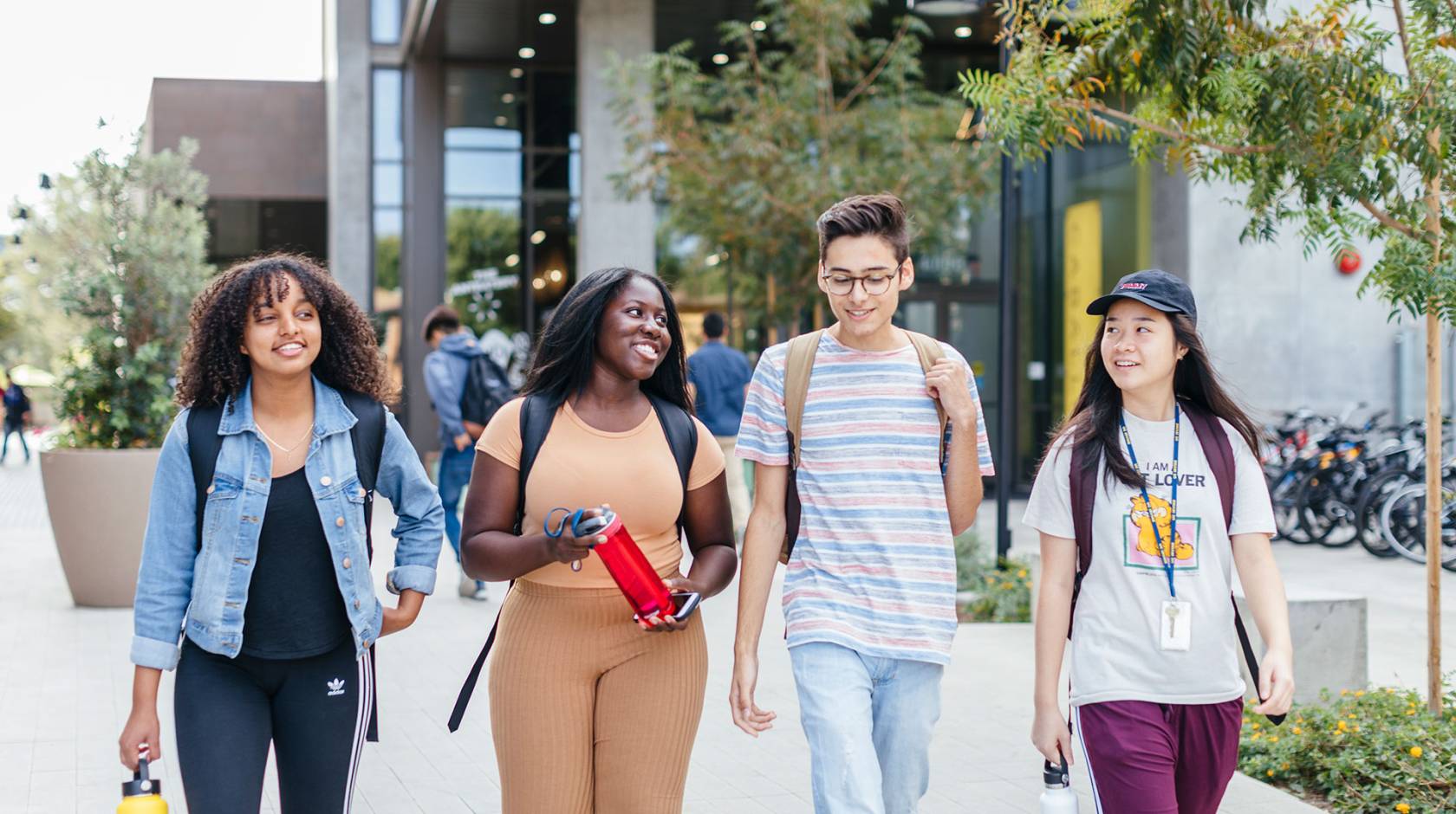 Group of four students walking on campus