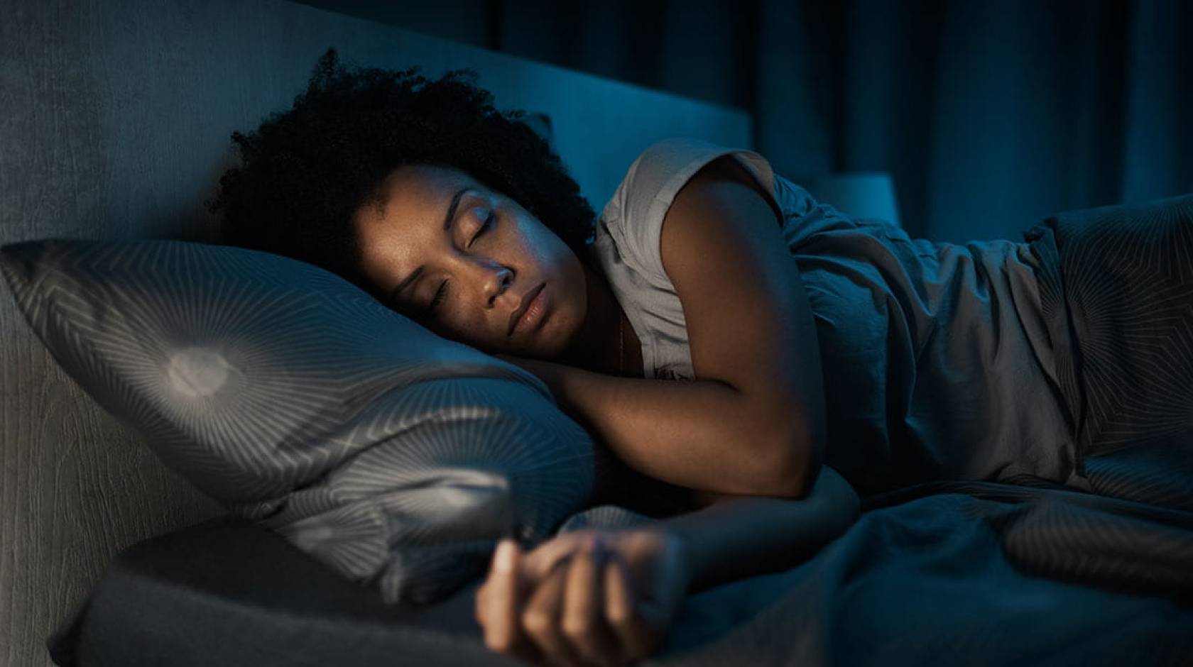 A person sleeping in bed in a dark room