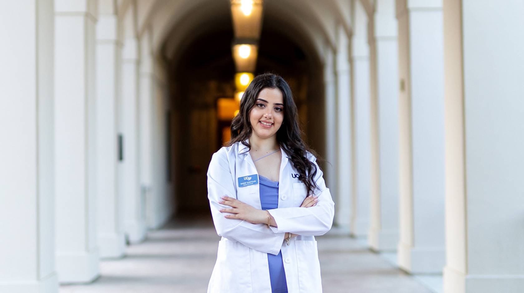 A smiling woman in a white doctor's coat