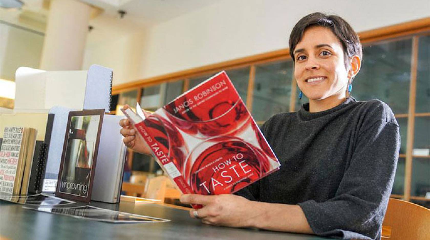 Jullianne Ballou reads a book on wine