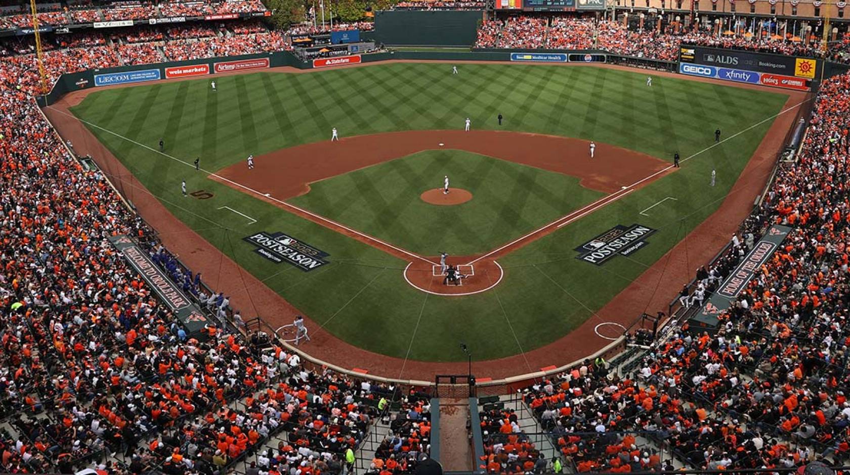 A view of a baseball stadium from behind home plate and many rows up