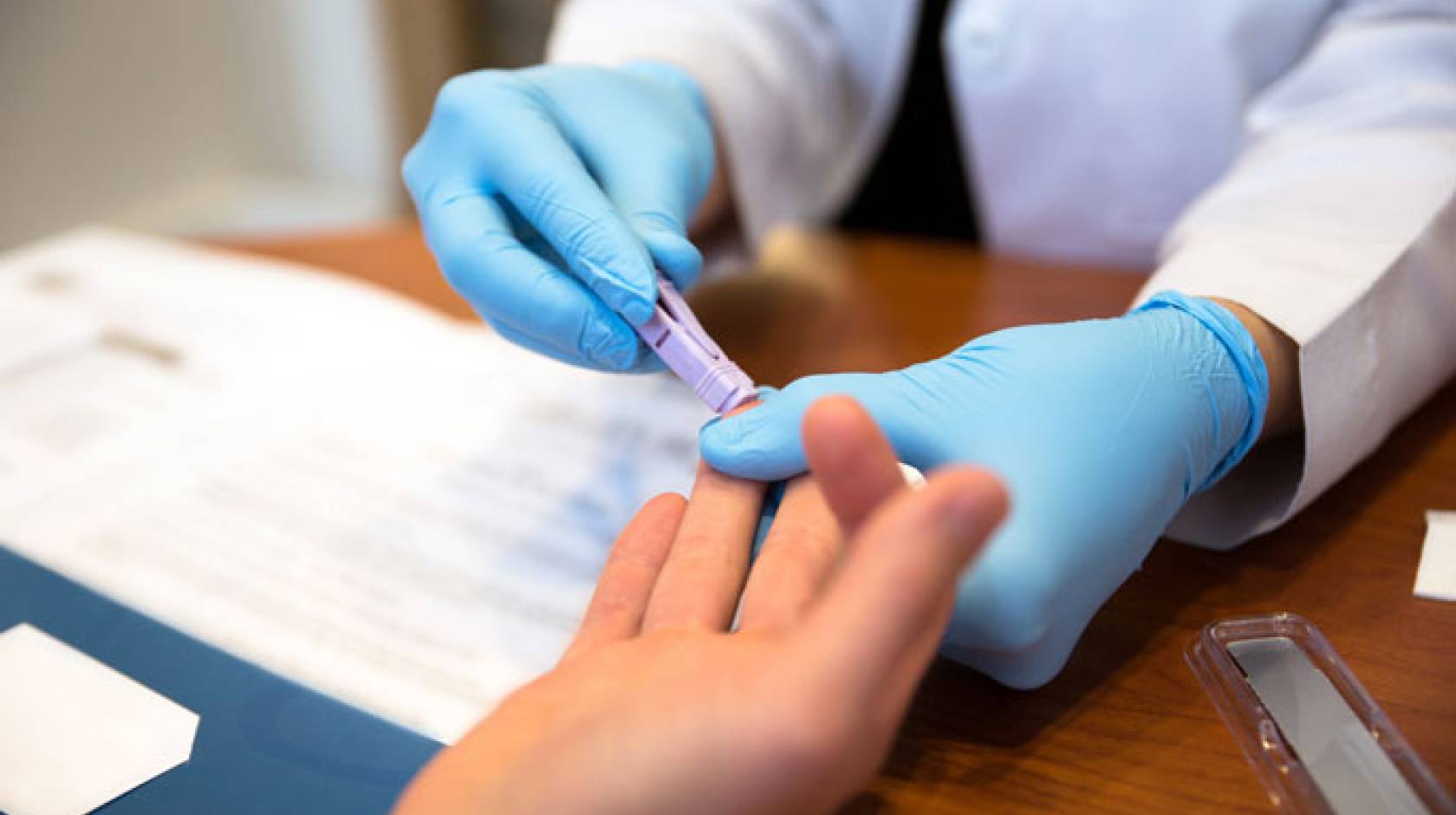 Blood test on finger being administered