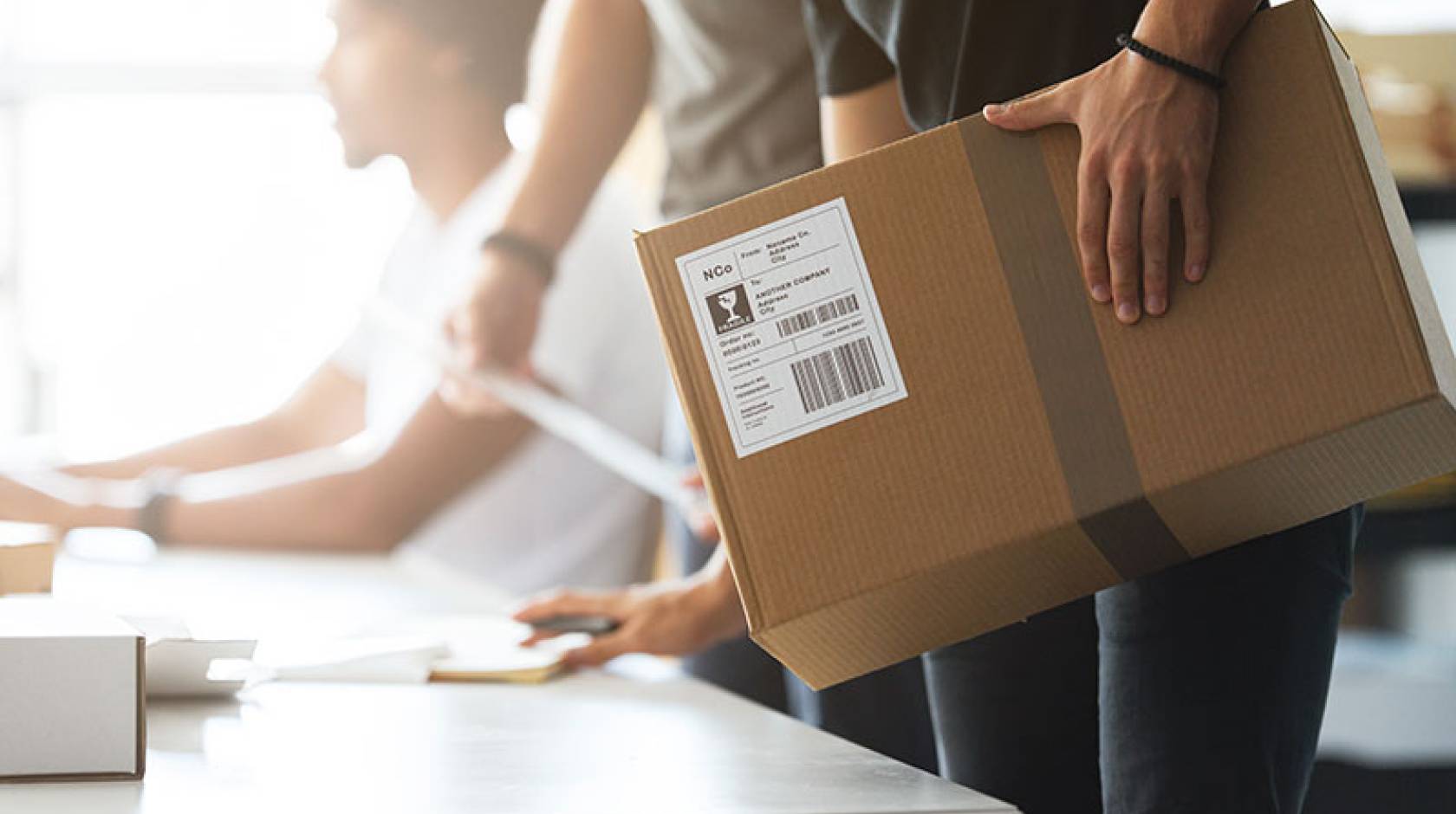 Man's hand on cardboard box 