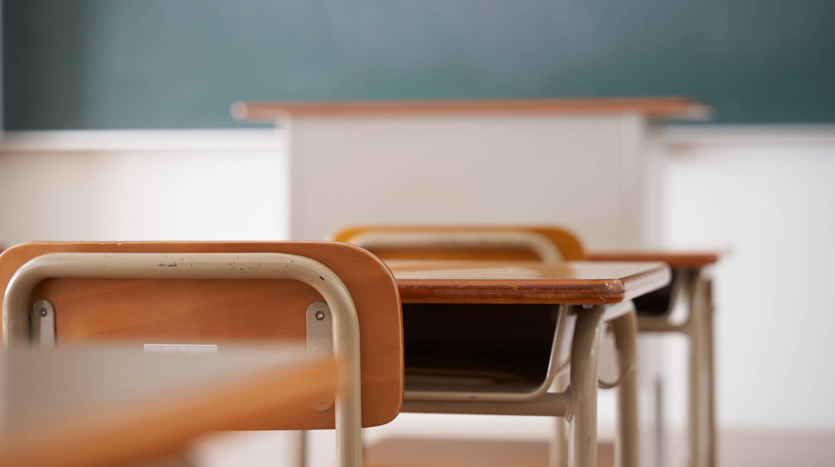 Classroom chairs and desks facing chalkboard